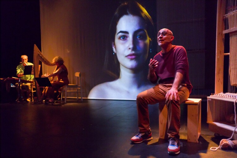 Escena de mariano Lasheras narrando con los músicos y la proyección de fondo